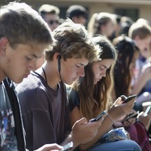 Young people looking intently at their smartphones in the sun, some wearing headphones, AI