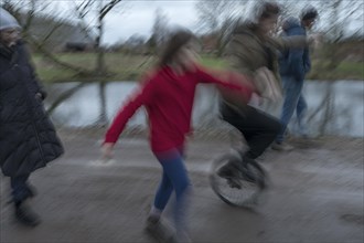 Family walk, a young woman with a unicycle, motion blur, Mecklenburg-.Vorpommern, Germany, Europe
