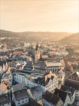 Warmly lit town with view of church and interlaced roofs, sunrise, Nagold, Black Forest, Germany,