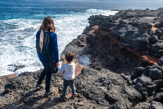 A mother with her son looking at the Bufadero de La Garita (Telde), Gran Canaria, Canary Islands