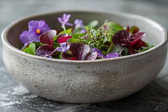 Gourmet salad with vibrant edible flowers and green leaves served in a ceramic bowl, AI generated