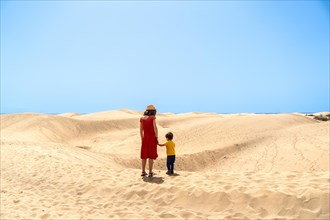 Mother and son on vacation very happy in the dunes of Maspalomas, Gran Canaria, Canary Islands