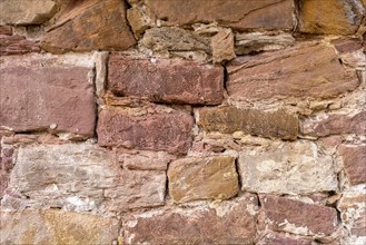 Wall made of sandstone, natural stone, quarry stone and mortar, background picture, old town,