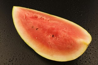Top view and close-up of half a Citrullus lanatus, Watermelon on black background with water