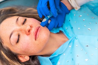 Close-up top view of a caucasian adult woman lying on stretcher with eyes closed during a beauty