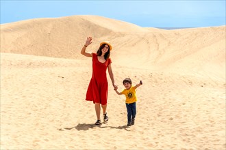 Mother and son tourists enjoying in the dunes of Maspalomas, Gran Canaria, Canary Islands