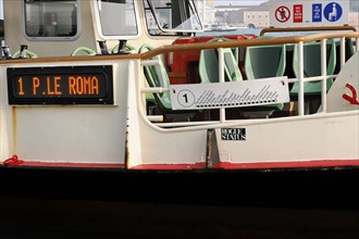 A sign on a boat shows the destination 'P.le Roma' next to seating, Venice, Veneto, Italy, Europe