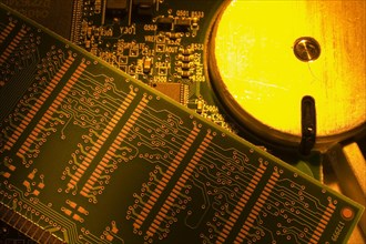 Close-up of orange and yellow lighted electronic computer circuit boards with hard drive, Studio