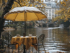 Gedeckter Tisch fuer zwei am regnerischen Ufer eines Flusses im Herbst, Lifestyle in Paris,