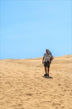 Tourist man with turban in summer walking in the dunes of Maspalomas, Gran Canaria, Canary Islands