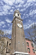 High tower with clock under a blue sky with clouds, Venice, Veneto, Italy, Europe