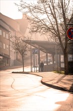 A foggy street in the morning light with a parking sign in the foreground, sunrise, Nagold, Black