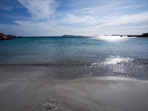 Waves reach the sandy beach, glittering sea, Capriccioli beach, Costa Smeralda, Sardinia, Italy,