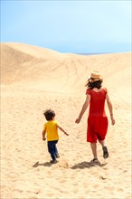 Mother and son tourists on vacation in the dunes of Maspalomas, Gran Canaria, Canary Islands