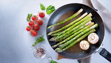 Fresh asparagus arranged in a pan with mushrooms and tomatoes on a cloth, green asparagus,