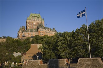 Historic Chateau Frontenac fairmont hotel building and old fortification wall with Quebec Fleur de