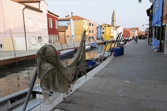 Colourful houses, Burano, Burano Island, A fishing boat with a net in the foreground against a