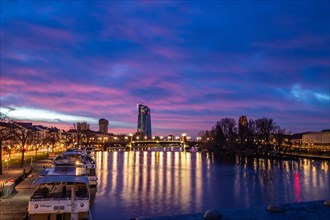 Sunrise on a riverbank in the centre of a big city. Spring with a view of the skyline of the