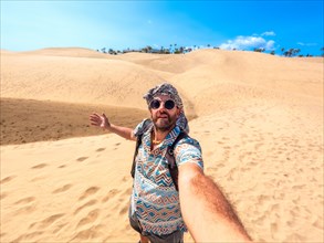 Selfie of a tourist with sunglasses and turban enjoying in the dunes of Maspalomas, Gran Canaria,