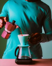Individual pouring coffee from a pink moka pot into a cup, against a vibrant teal backdrop,