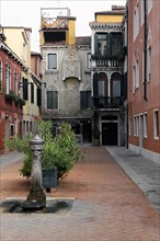 Typical Venetian courtyard with fountain and green plant, Venice, Veneto, Italy, Europe
