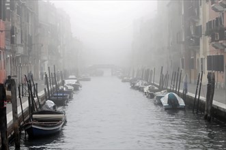 A foggy canal in Venice creates a mystical and tranquil atmosphere, Venice, Veneto, Italy, Europe