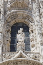 Arched window decorated with carved sculptures on facade of Jeronimos Monastery, Lisbon, Portugal,