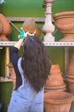 Woman selecting a terracotta ornament in a pottery studio