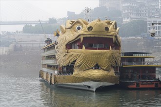 Yichang, Hubei Province, China, Asia, A ship in the shape of a golden dragon's head floats on a