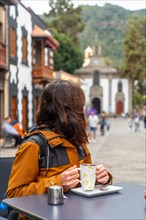 A tourist woman resting and having a coffee in the municipality of Teror. Gran Canaria, Spain,