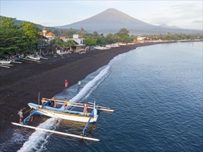 Fishermen loading fish from their outrigger boats in the morning on the black beach of Amed, Mount