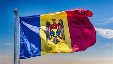 The flag of Moldova, Republic of Moldova, flutters in the wind, isolated against a blue sky