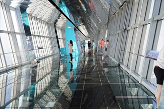 Viewing terrace, The Bottle Opener at 492 metres, people walk along a glass viewing corridor with