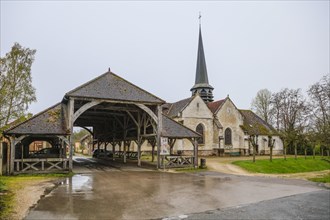 Open market hall and church in the village of Lesmont, Aube department, Grand Est region, France,