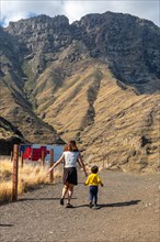 A mother and her son walking and having fun in the mountains of the Agaete coast, Roque Guayedra,