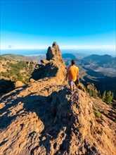 A man looking at the top of Pico de las Nieves in Gran Canaria, Canary Islands. vertical photo