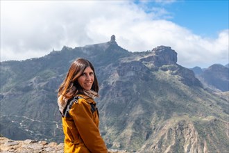 Portrait of a woman looking at Roque Nublo from a viewpoint on the mountain. Gran Canaria, Spain,