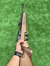 Vertical image of a hand holding a shotgun