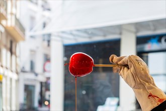 A hand holds a candied apple in Sitges, Spain, Europe