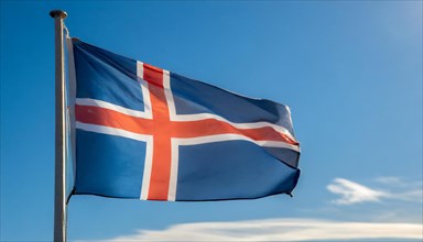 The flag of Iceland flutters in the wind, isolated against a blue sky