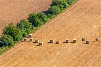 Aerial view at some straw bales on a stubble field after harvest