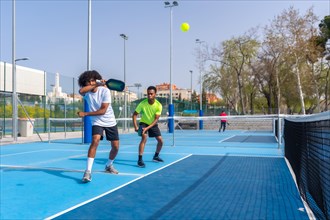 Full length photo with copy space of two african sportive friends playing pickleball together