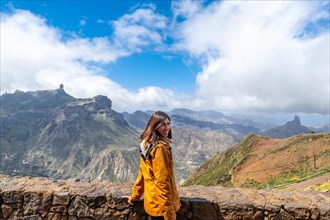 Portrait of a woman looking at Roque Nublo from a viewpoint on the mountain. Gran Canaria, Spain,