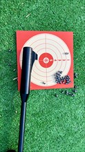 Air rifle for training with its target and its pellets on the grass