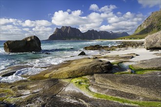 Seascape on the beach at Uttakleiv (Utakleiv), rocks and green seaweed in the foreground. In the