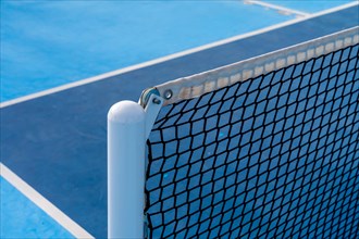 Close-up photo of the detail of a new tennis net on a pickleball court