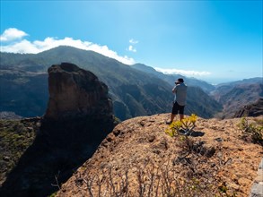 A photographer at the Roque Palmes viewpoint near Roque Nublo in Gran Canaria, Canary Islands