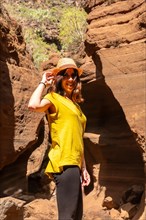 Portrait of a woman with hat in the limestone canyon Barranco de las Vacas in Gran Canaria, Canary