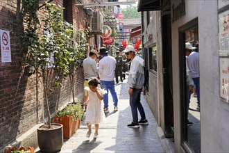 Strolling through the restored Tianzifang neighbourhood, people walking through a cobblestone alley