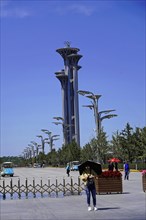 Beijing, China, Asia, Person walking with parasol in front of Olympic tower on a sunny day, Asia